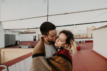 Couple embracing with blanket in a terrace - ADSF01509