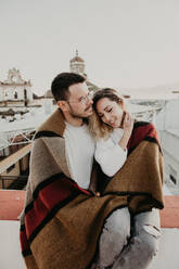 Couple embracing with blanket in a terrace - ADSF01510