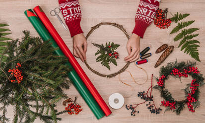 Hände auf Holztisch mit Weihnachtsdekoration - ADSF01591