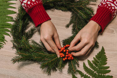 Hände auf Holztisch mit Weihnachtsdekoration - ADSF01597