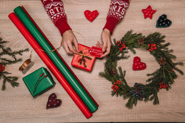 Crop woman tying a ribbon of a christmas gift surrender of decoration - ADSF01603