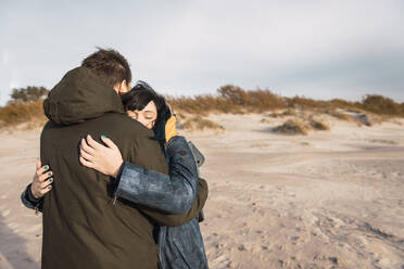 Couple outdoors embracing at beach - ADSF01606