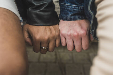 Close-up of gay couple hands on table stock photo