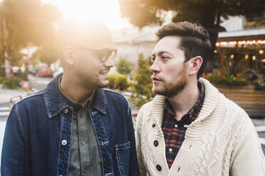 Close-up of gay couple looking at each other while standing in city - DSIF00030