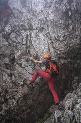 Mature man with backpack climbing on mountain, Bergamasque Alps, Italy - MCVF00536