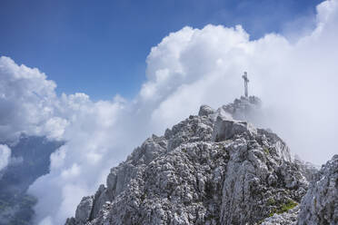 Gipfelkreuz auf Berggipfel gegen bewölkten Himmel, Bergamasker Alpen, Italien - MCVF00543