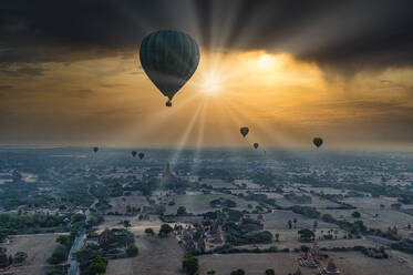Myanmar, Region Mandalay, Bagan, Heißluftballons fliegen über alte Stupas bei dramatischem Sonnenaufgang - RUNF03883