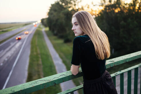 Frau auf der Brücke in der Nähe der Autobahn - CAVF87237