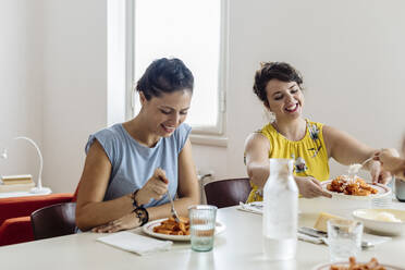 Fröhliche Frauen genießen ein gesundes Abendessen zu Hause - CAVF87278