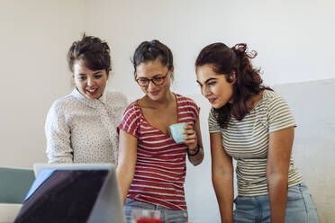 Content diverse women surfing laptop creating new startup - CAVF87282