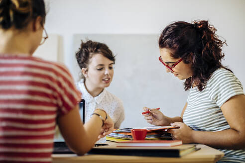 Lässige Frauen, die an einem Tisch Startup-Ideen diskutieren - CAVF87283