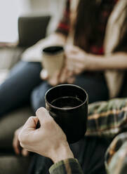 Nahaufnahme von zwei Personen mit vollen Kaffeetassen. selektiver Fokus - CAVF87336