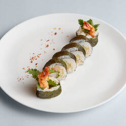 Helle köstliche japanische Sushi-Rollen mit Lachs in fliegenden Fischkaviar schön auf weißem Teller auf weißem Hintergrund von oben gesetzt - ADSF01680