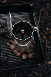 Kaffee in der Kaffeemaschine auf dem Herd über der warmen Holzkohle in der Grillpfanne - ADSF01694