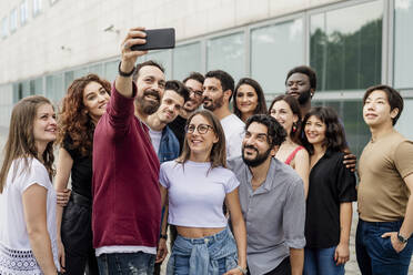 Mann macht Selfie mit einer Gruppe von Freunden in der Stadt - MEUF01509