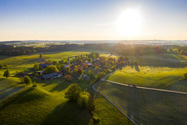 Deutschland, Bayern, Peretshofen, Luftaufnahme eines ländlichen Dorfes bei Sonnenuntergang - LHF00802
