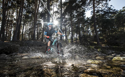 Biker fährt mit dem Fahrrad über einen Fluss - ADSF01738