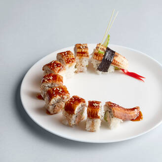 Helle köstliche japanische Sushi-Rollen mit Lachs in fliegenden Fischkaviar schön auf weißem Teller auf weißem Hintergrund von oben gesetzt - ADSF01837