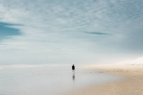 Mensch am Sandstrand in der Nähe von Wasser und bewölktem Himmel - ADSF01992