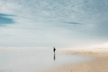 Seitenansicht Person mit Rucksack stehen am Ufer in der Nähe von Wasser und schönen Himmel mit Wolken in Frankreich - ADSF01993