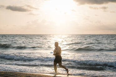 Strong old man makes exercise on the beach. - ADSF02081