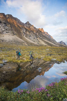 Reflexion von Rucksacktouristen beim Wandern über den Akshayak-Pass, Kanada. - CAVF87345