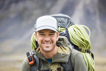 Porträt eines Bergsteigers mit Rucksack, Seil und GPS-Kommunikationsgerät - CAVF87350