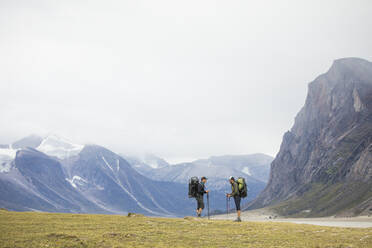 Zwei Freunde halten während einer Rucksacktour an und besprechen die Route. - CAVF87353