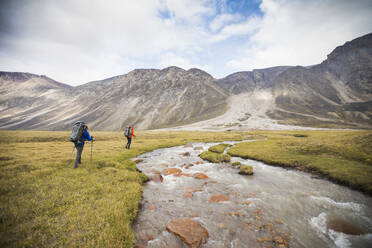 Two backpackers hike upstream of river to find safe crossing. - CAVF87357