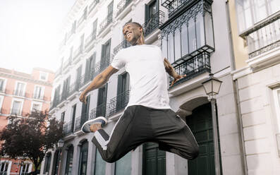 African man shirt jumping front building. - ADSF02128