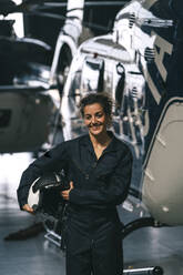 Pilotin posiert mit ihrem Hubschrauber und Helm - ADSF02166