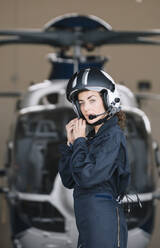 Pilotin posiert mit ihrem Hubschrauber und Helm - ADSF02170