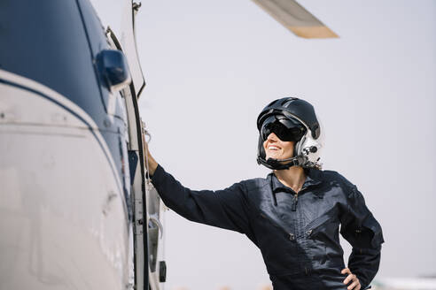 Pilotin posiert mit ihrem Hubschrauber und Helm - ADSF02176