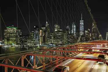 Fahrzeuge fahren auf einer modernen Brücke über den Fluss in der majestätischen Stadt New York bei Nacht - ADSF02220