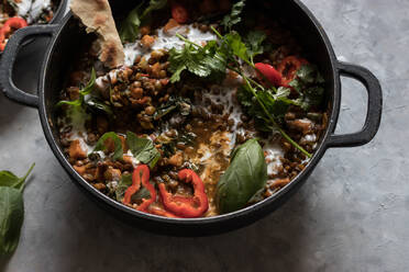 Bowl near pot with ragout of lentil and sweet potato curry - ADSF02393