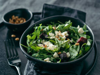 Salat aus Roter Bete, Aragula und Weichkäse auf grauem Leinentischtuch. - ADSF02426
