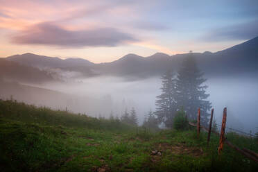 Nebliger farbenfroher Sonnenaufgang im Gebirgstal - ADSF02574