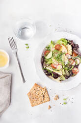 Von oben schmackhafter frischer Gemüsesalat mit Crackern auf weißem Tisch serviert. - ADSF02589