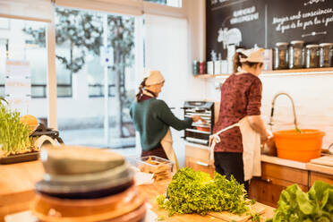 Seitenansicht einer hübschen Köchin, die in der Küche eines Restaurants arbeitet. - ADSF02752