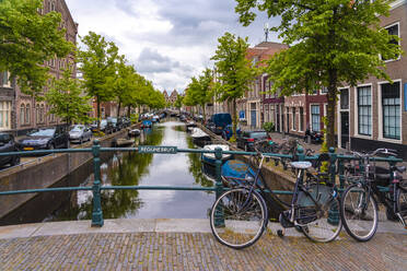 Niederlande, Nordholland, Haarlem, Fahrräder am Geländer einer Grachtenbrücke abgestellt - TAMF02537