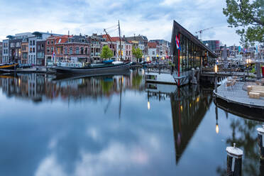 Niederlande, Südholland, Leiden, Gebäude, die sich in der Abenddämmerung im Oude Rijn-Kanal spiegeln - TAMF02601