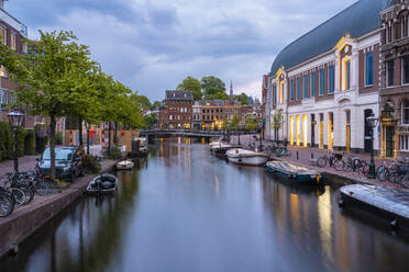 Niederlande, Südholland, Leiden, Boote entlang des Rheins Stadtkanal in der Abenddämmerung vertäut - TAMF02604
