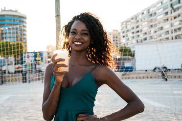 Wunderschöne schwarze Frau mit Getränk vor einem Netz - ADSF02910