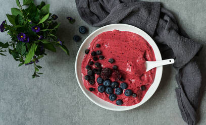 Smoothy of fresh bog blueberries and raspberries in bowl near napkin - ADSF03044