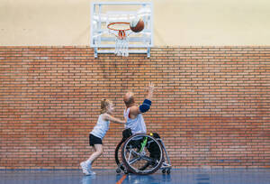 Behindertensportler und kleines Mädchen in Aktion beim Indoor-Basketballspielen - ADSF03052