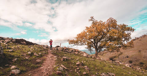 Side view of anonymous person standoion narrow path near beautiful autumn day on cloudy day in Extremadura, Spain - ADSF03096