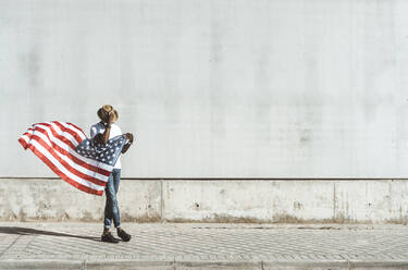 Happy black man with flying American flag - ADSF03117