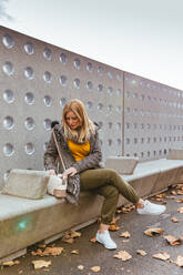 Portrait of blond girl looking in her bag - ADSF03162