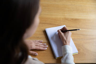 Junge Frau schreibt ihre Ideen in ein Notizbuch - ADSF03181