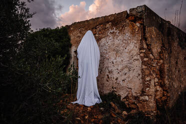 Zu Halloween als Geist verkleidete Person neben einer Hausruine - ADSF03194